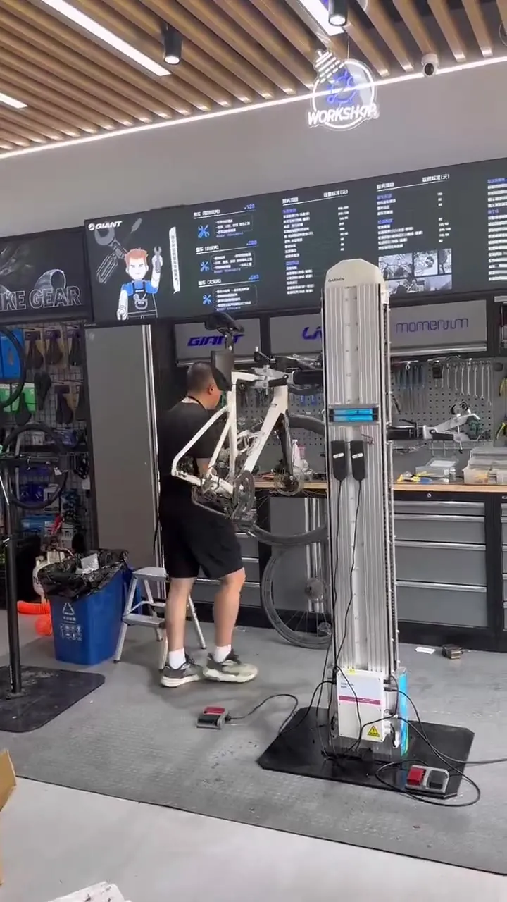 Bike lifting demo in a retail workshop — raised smoothly by foot pedal control